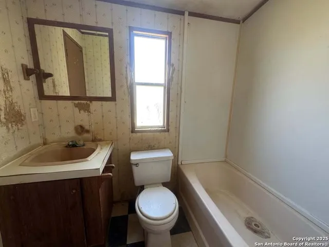 a bathroom with a sink a toilet and a mirror