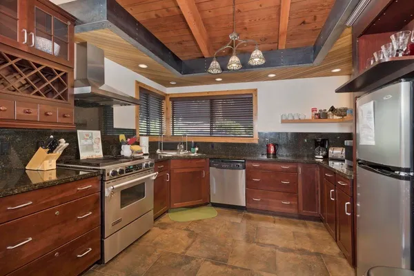 a kitchen with stainless steel appliances granite countertop a stove a sink and a microwave