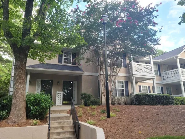 a front view of a house with a tree