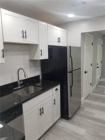 a kitchen with stainless steel appliances a refrigerator sink and cabinets