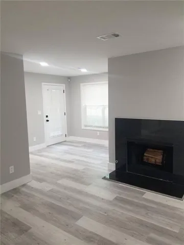a view of an empty room with a fireplace and a window