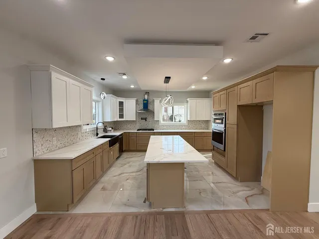 a large kitchen with a large counter top appliances and cabinets