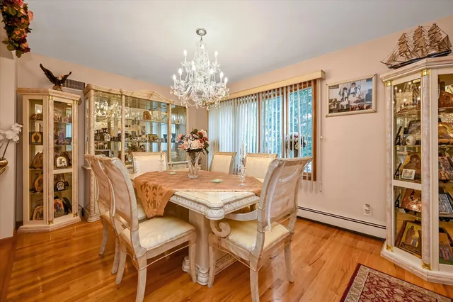 a view of a dining room with furniture a chandelier and wooden floor