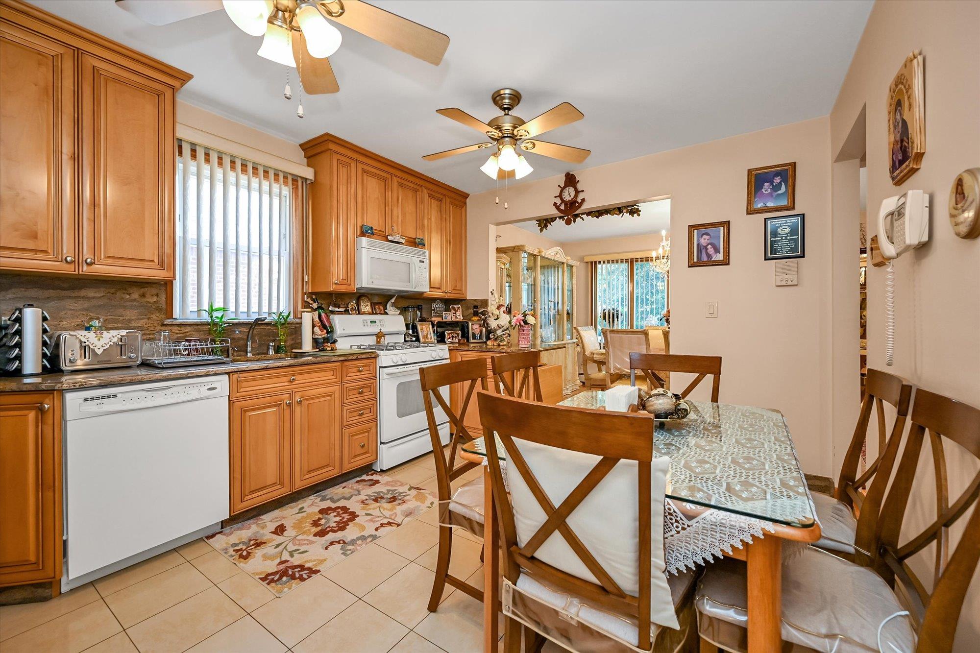 45-39 192nd Street Queens, NY 11358 - Photo 14 of 23 a kitchen with stainless steel appliances granite countertop a sink a stove a dining table and chairs with wooden floor