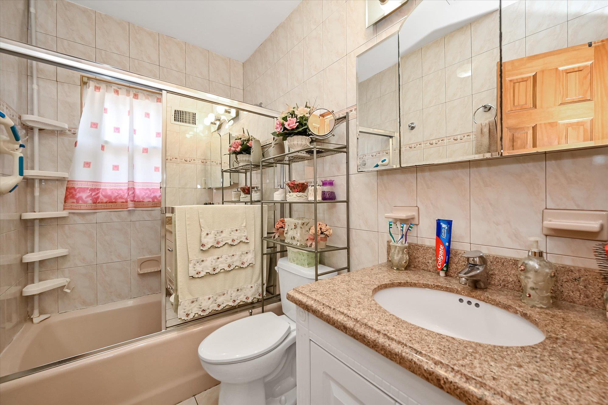 45-39 192nd Street Queens, NY 11358 - Photo 17 of 23 a bathroom with a granite countertop sink a toilet and shower