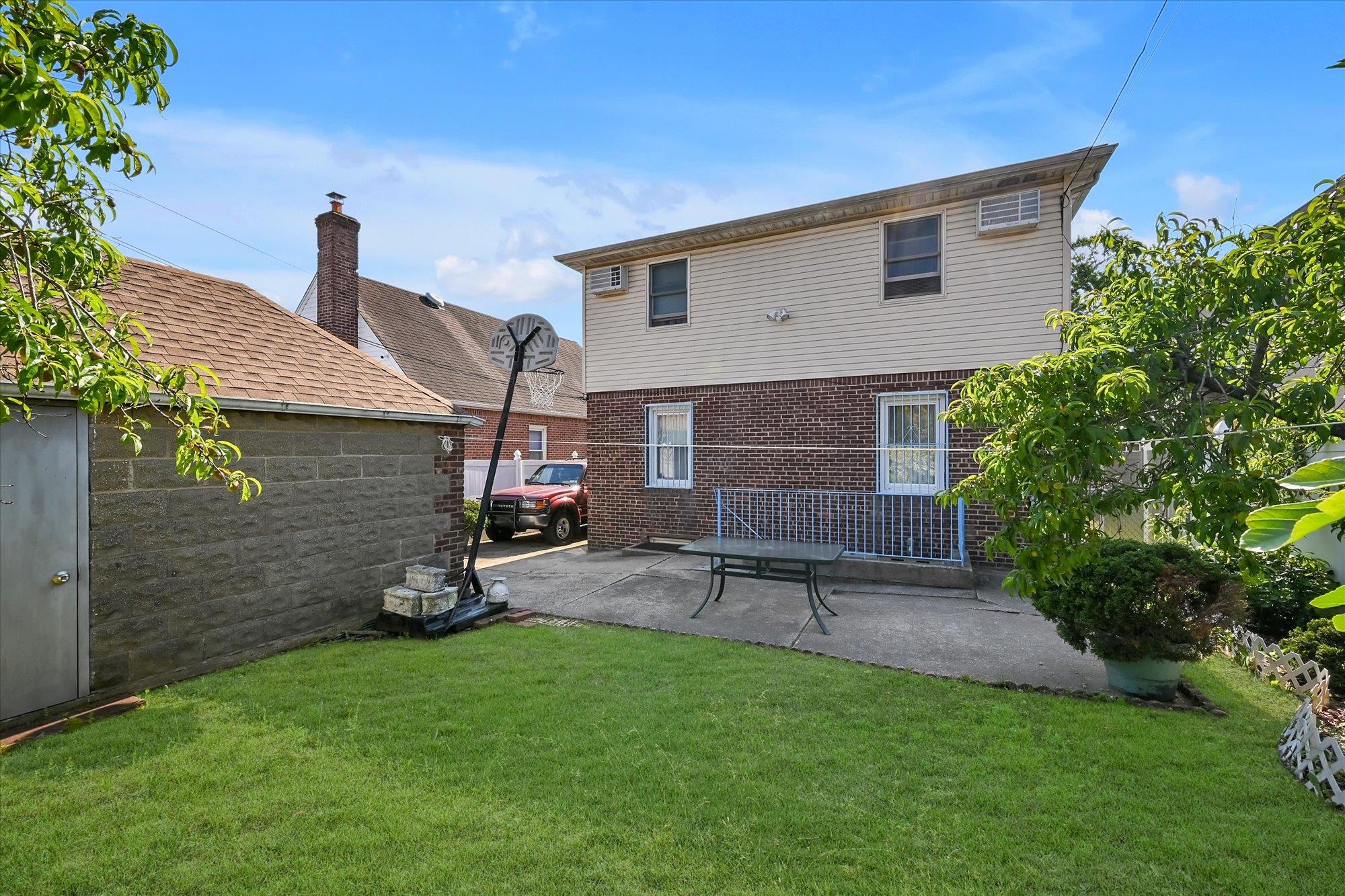 45-39 192nd Street Queens, NY 11358 - Photo 20 of 23 a front view of a house with a garden and sitting area