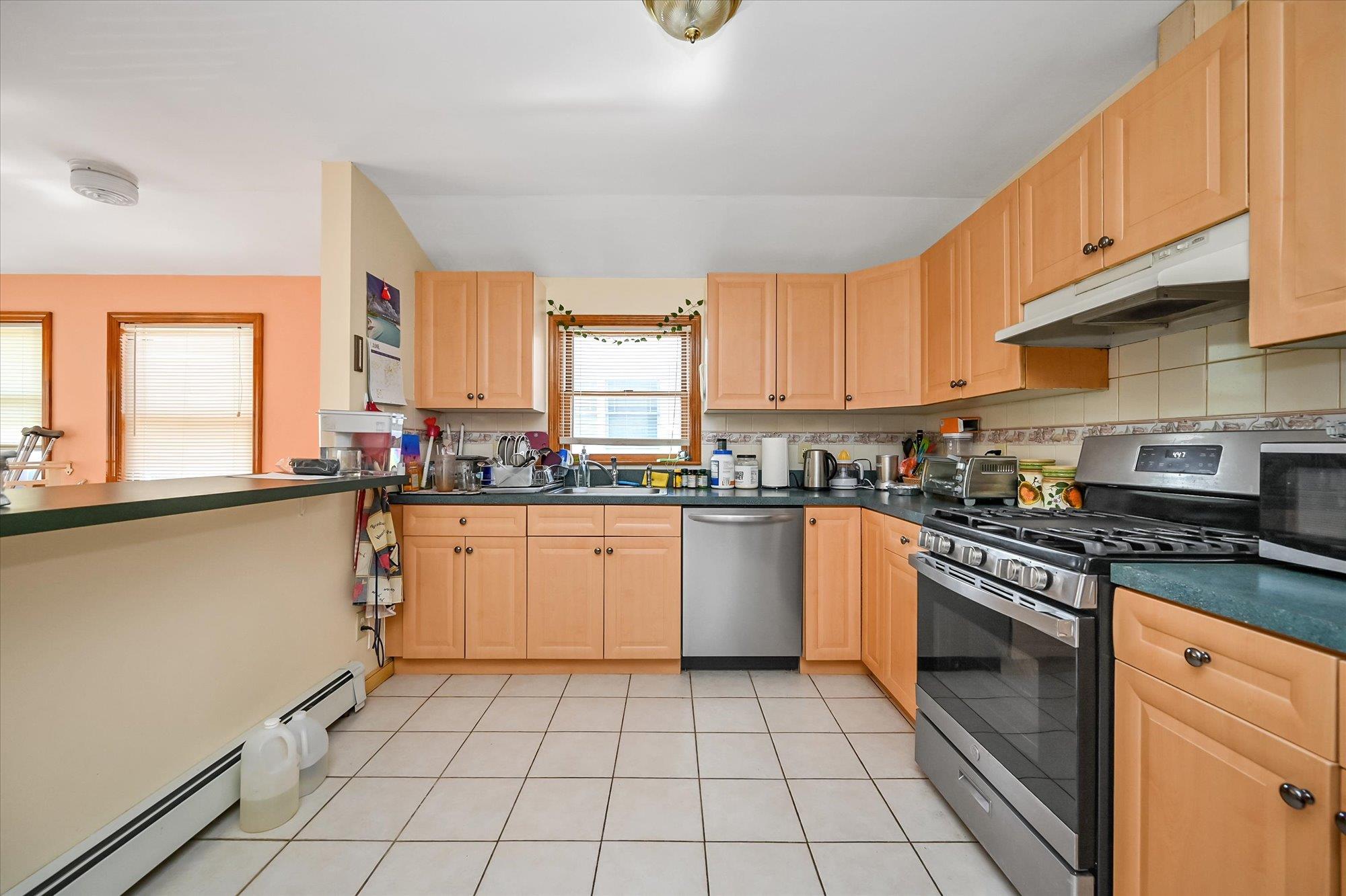 45-39 192nd Street Queens, NY 11358 - Photo 6 of 23 a kitchen with stainless steel appliances granite countertop a stove a sink and a microwave
