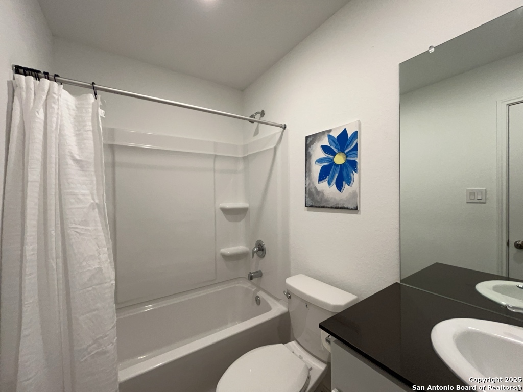 6954 Biotite Ridge Elmendorf, TX 78112 - Photo 21 of 39 a bathroom with a granite countertop bathtub shower sink vanity and toilet