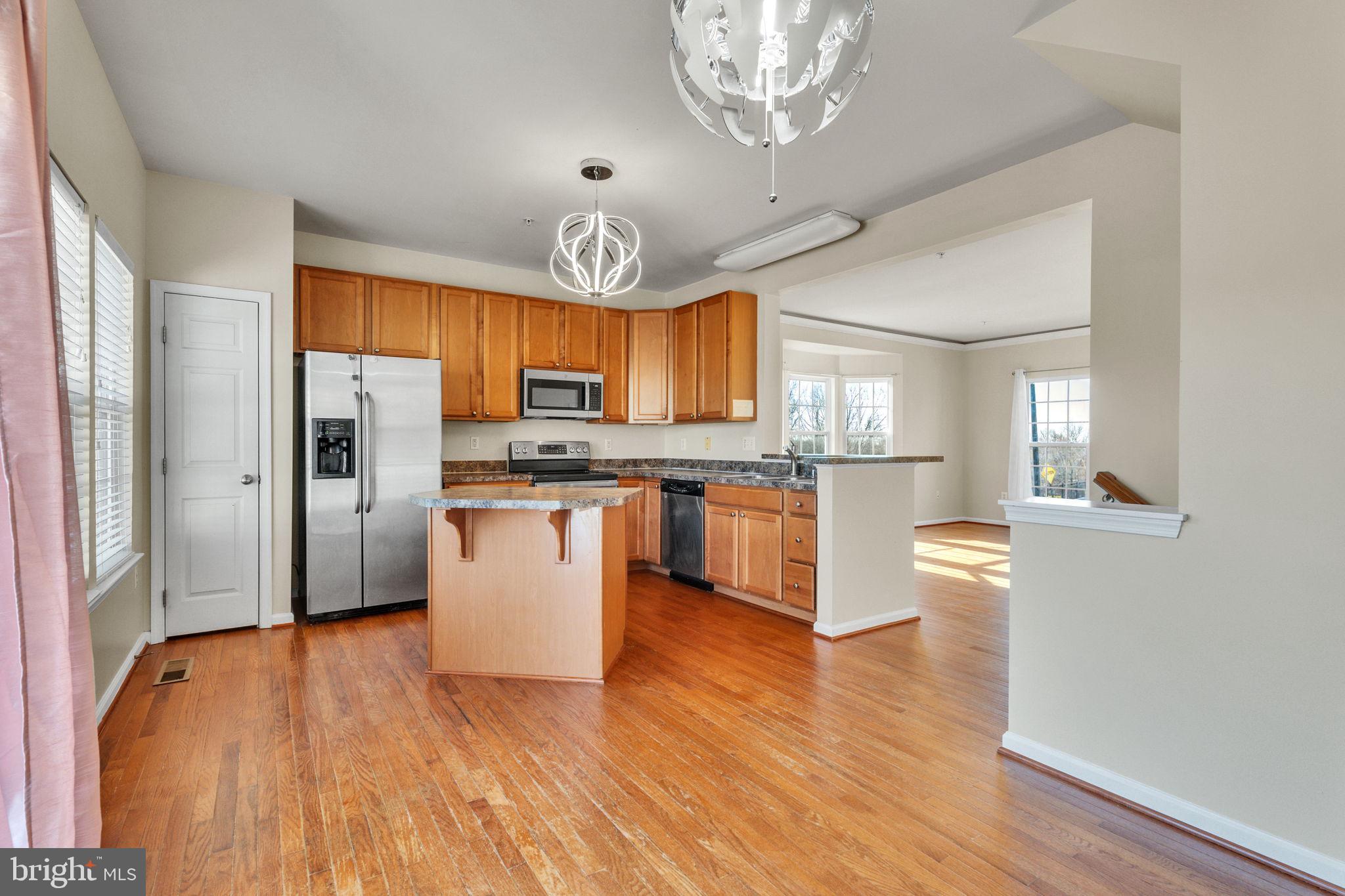 25501 Joy Lane Damascus, MD 20872 - Photo 20 of 35 a kitchen with stainless steel appliances granite countertop a refrigerator a stove top oven a sink dishwasher and white cabinets with wooden floor