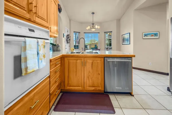 a view of kitchen with granite countertop cabinets and refrigerator