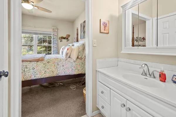 a en suite bathroom with a sink window and mirror
