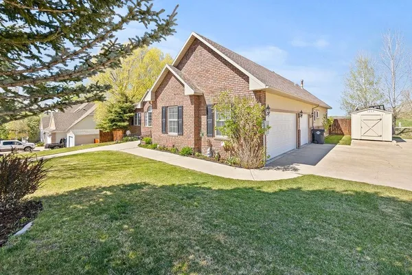 a view of a house with a yard and large tree