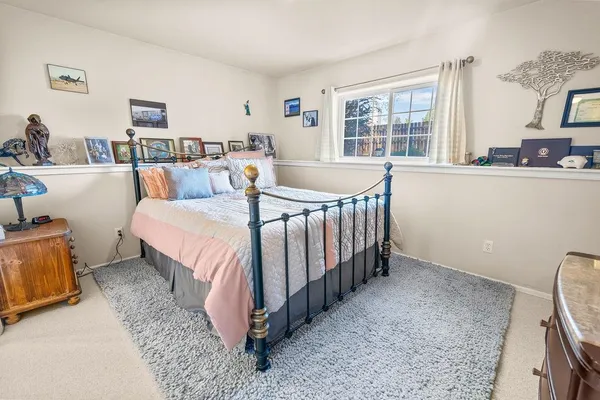 a bed sitting in a bedroom next to a window