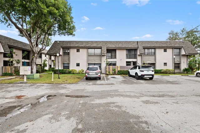 a view of a house with a yard and potted plants