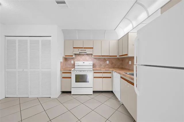 a kitchen with white cabinets and white appliances
