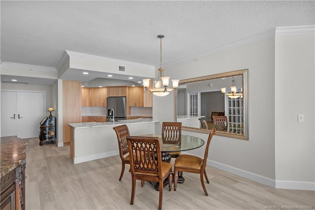 8600 South Ocean Drive, Unit PH5 Jensen Beach, FL 34957 - Photo 11 of 49 a dining room with furniture a chandelier and wooden floor