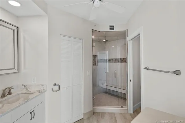 a bathroom with a granite countertop sink mirror and shower