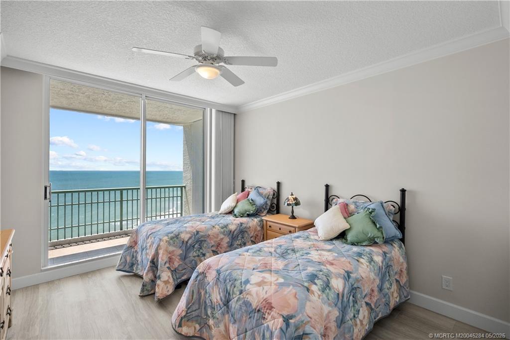 8600 South Ocean Drive, Unit PH5 Jensen Beach, FL 34957 - Photo 29 of 49 a bedroom with two beds and a large window with balcony view