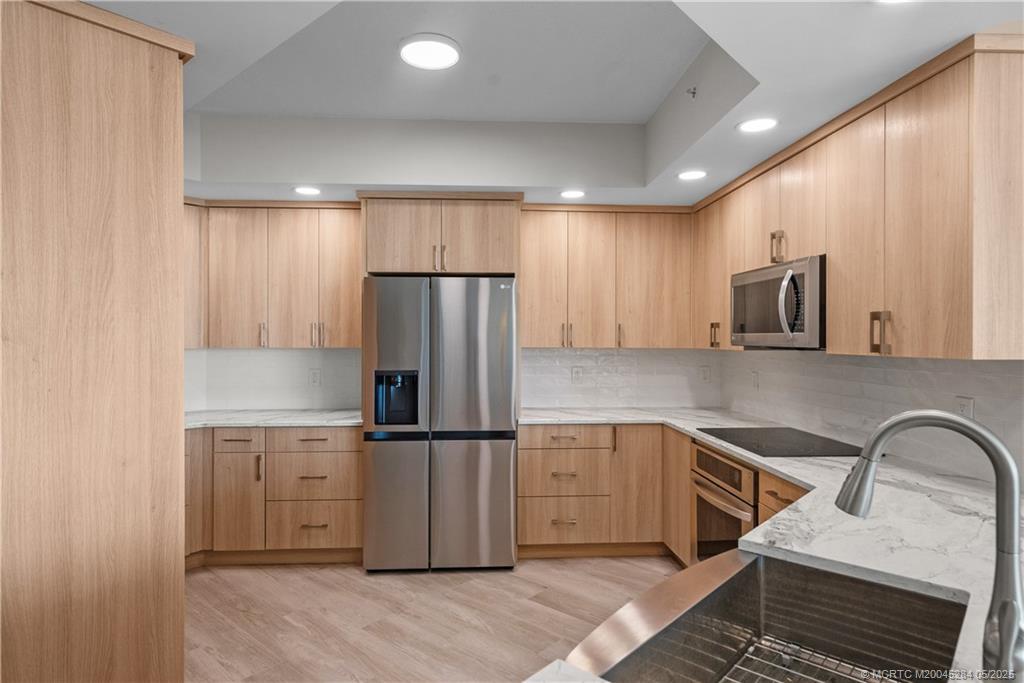 8600 South Ocean Drive, Unit PH5 Jensen Beach, FL 34957 - Photo 6 of 49 a kitchen with kitchen island granite countertop cabinets and stainless steel appliances