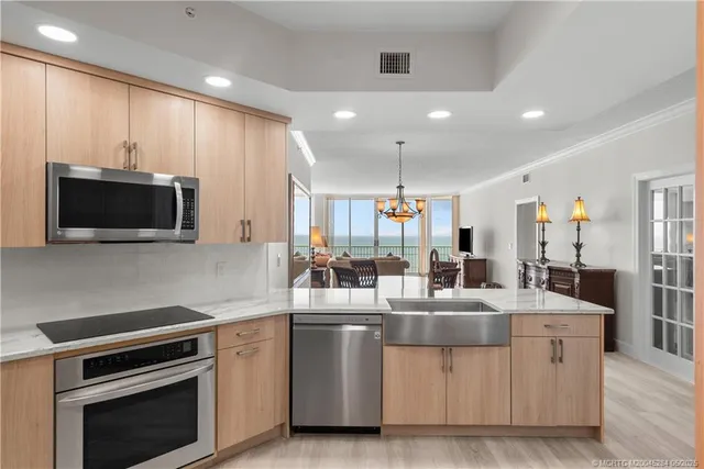 a kitchen with stainless steel appliances kitchen island granite countertop a stove and a sink