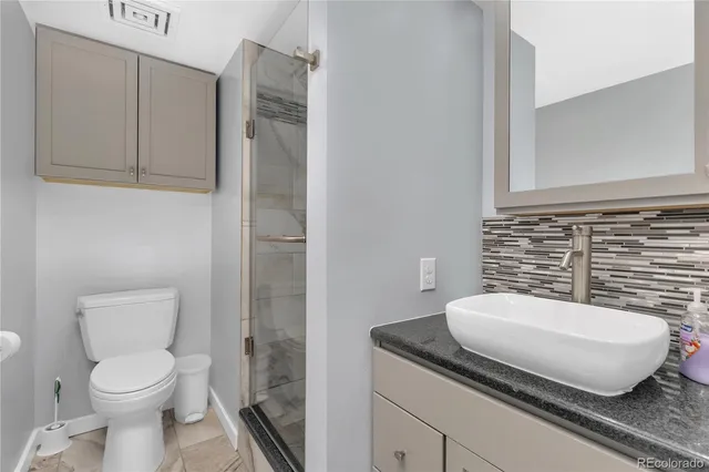 a bathroom with a granite countertop toilet and sink