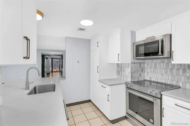a kitchen with a sink and a stove top oven with wooden floor