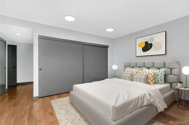 a bedroom with a bed and painting on the wall