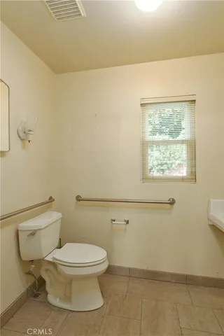 a bathroom with a sink a toilet and a window