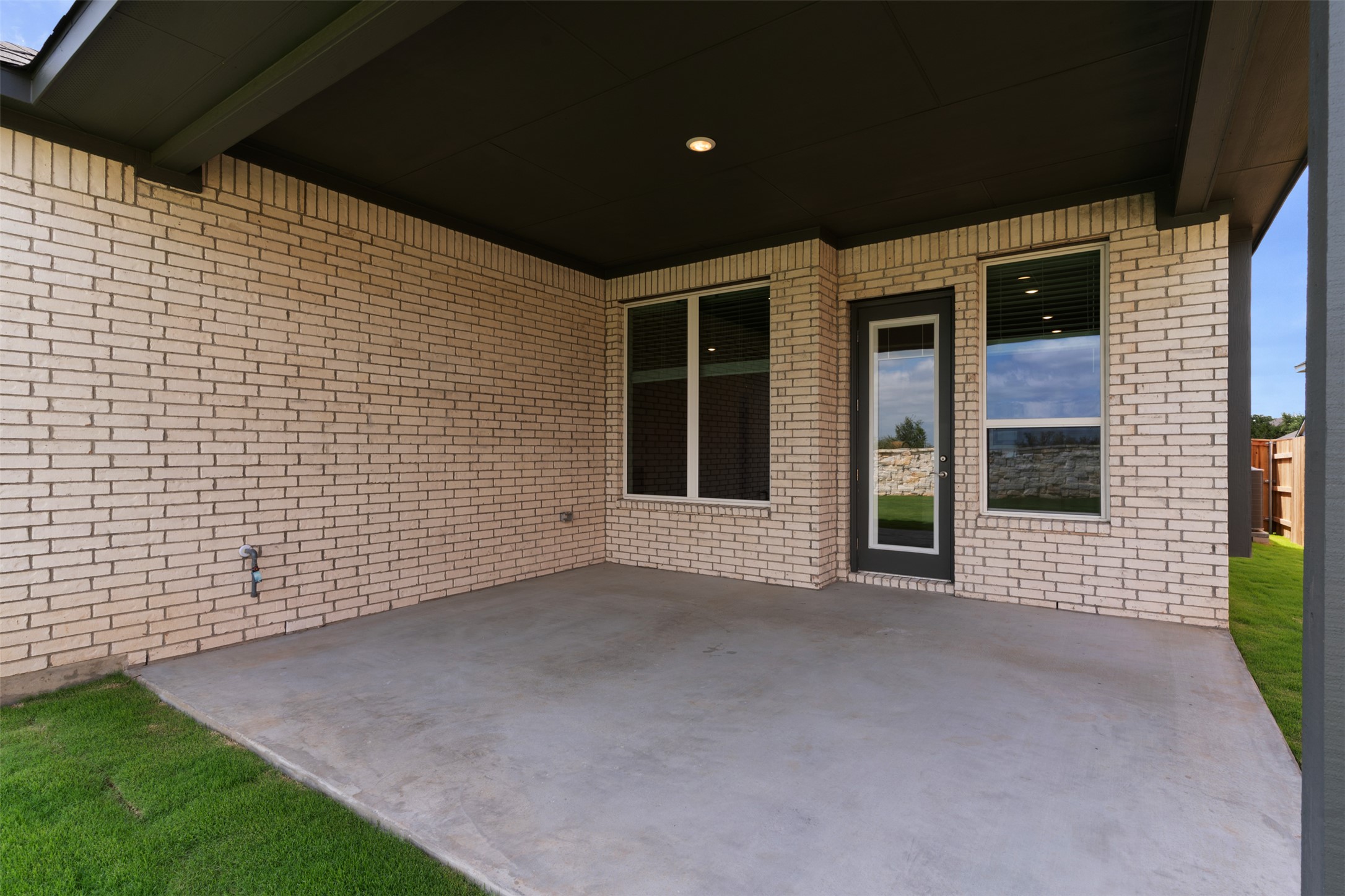 1129 Pansy Trail Georgetown, TX 78628 - Photo 20 of 29 Covered outdoor patio featuring a concrete slab, recessed lighting, light-toned brick exterior, multiple window openings, and a glass-paneled exterior door