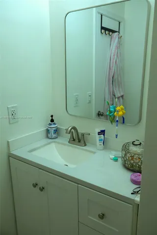 a bathroom with a sink vanity and a mirror