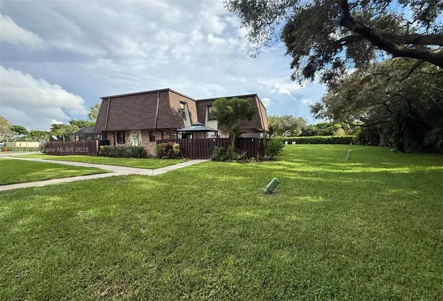 a view of a big yard with table and chairs and a slide