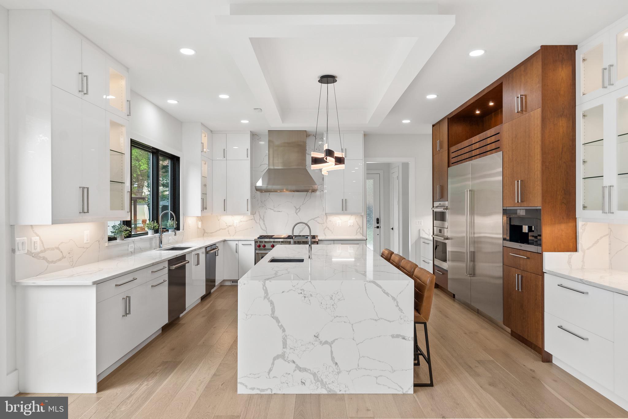 8100 Lewinsville Road McLean, VA 22102 - Photo 23 of 49 a large white kitchen with kitchen island a stove a sink a refrigerator and cabinets