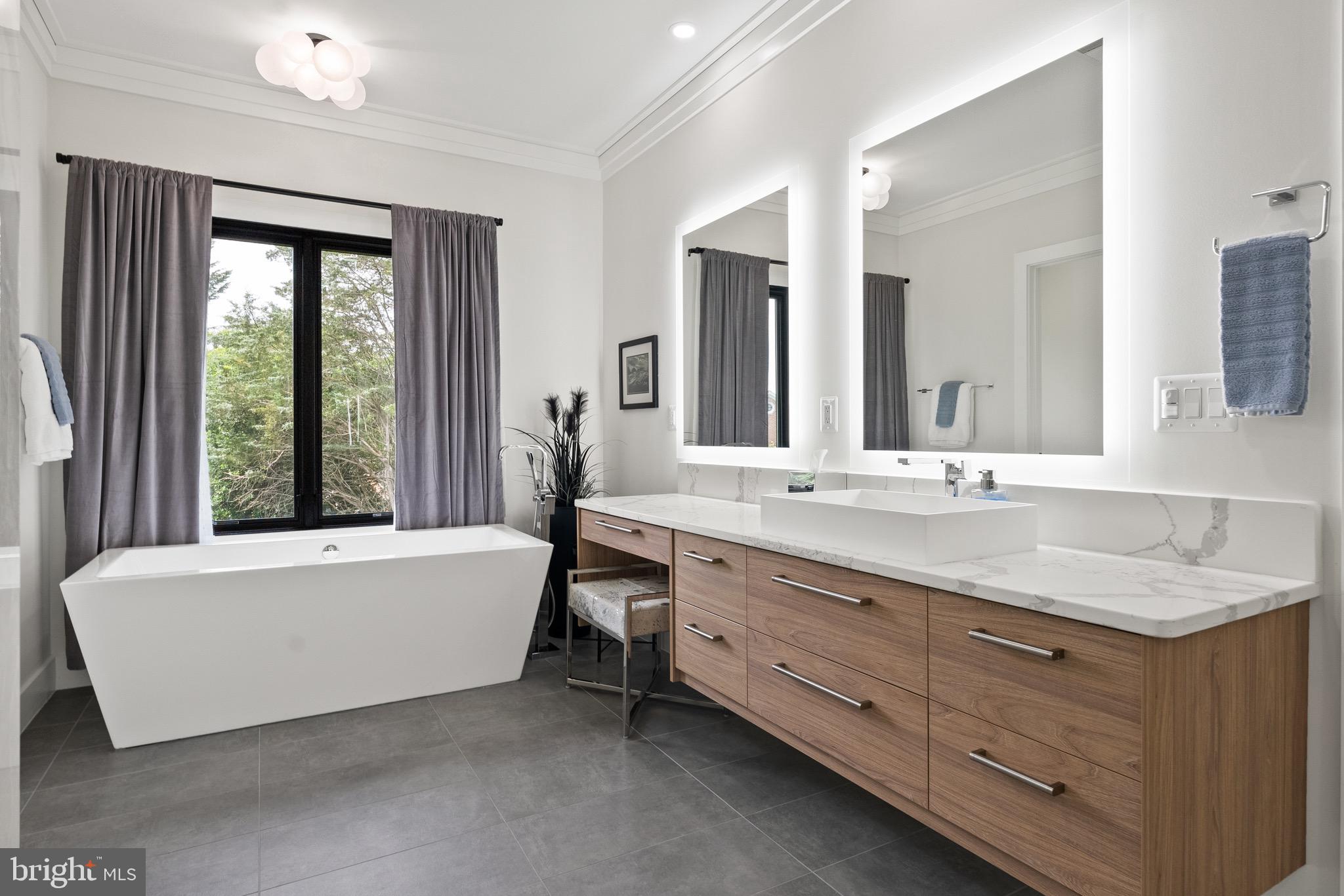 8100 Lewinsville Road McLean, VA 22102 - Photo 36 of 49 a bathroom with a granite countertop bathtub a sink and a large mirror