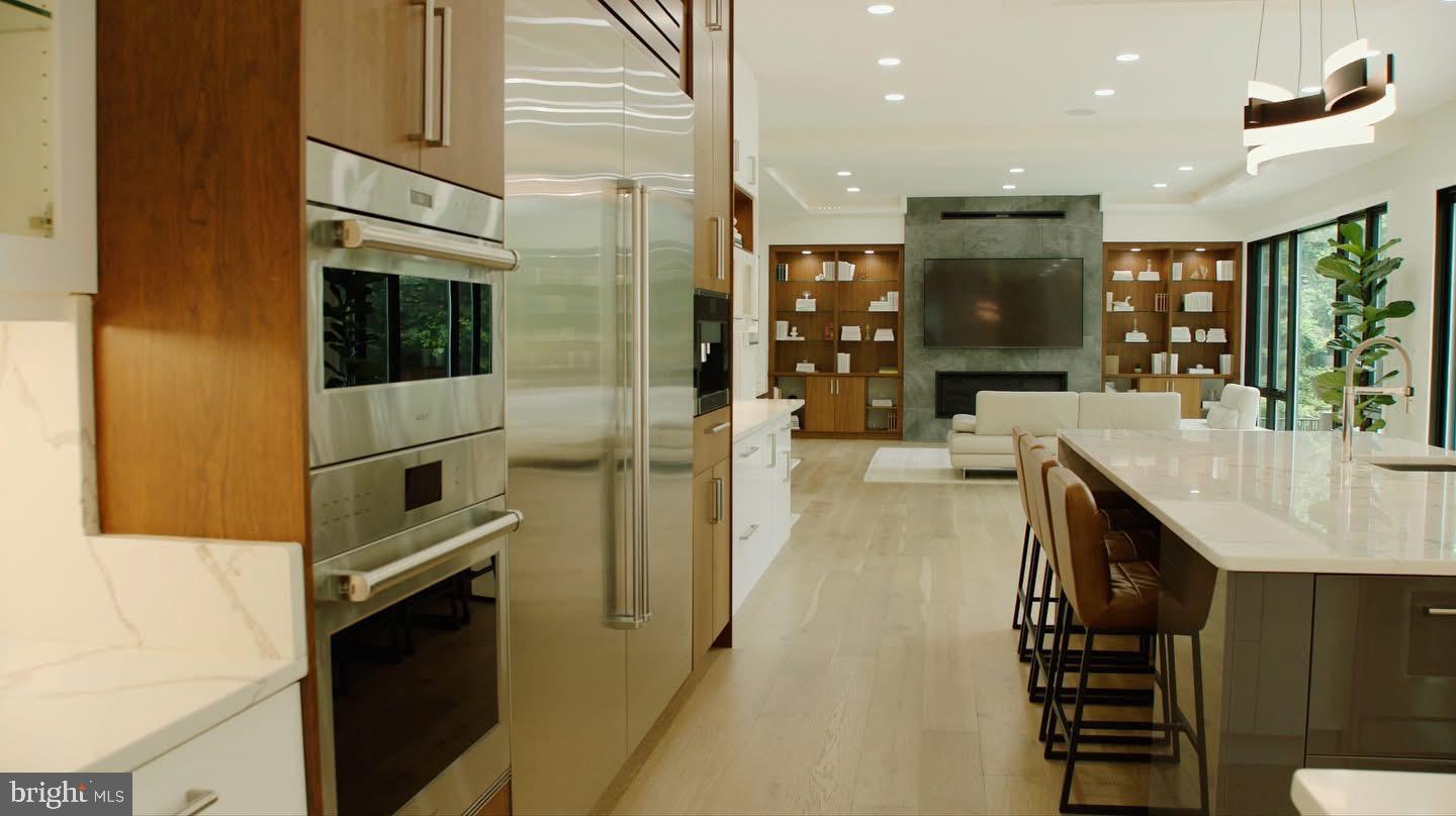 8100 Lewinsville Road McLean, VA 22102 - Photo 6 of 49 a kitchen with stainless steel appliances kitchen island granite countertop a refrigerator a stove and a sink