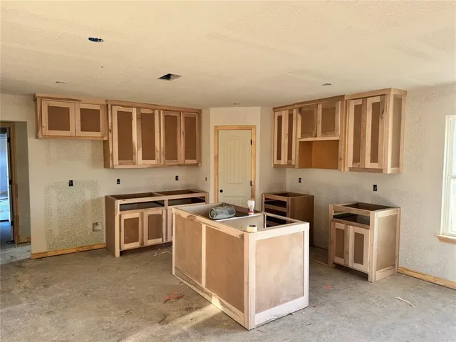 a utility room with stainless steel appliances granite countertop a stove and a sink