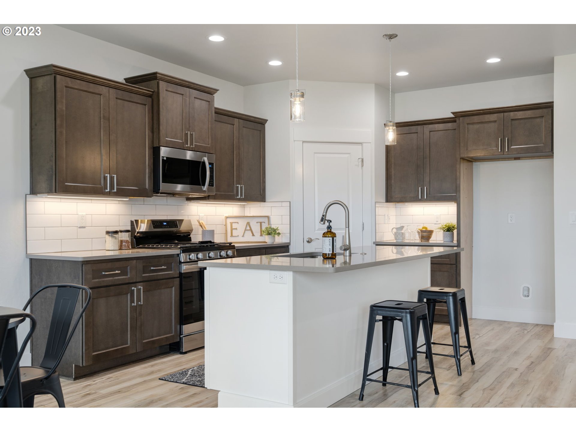 318 Sage Street Boardman, OR 97818 - Photo 9 of 20 a kitchen with kitchen island white cabinets stainless steel appliances and sink