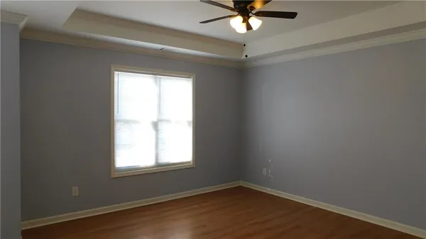 an empty room with a window and a fan