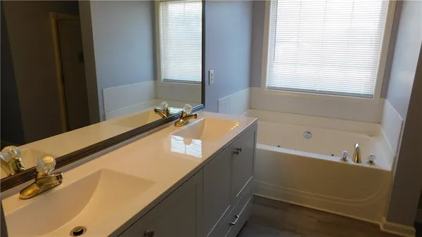 a bathroom with a tub sink and mirror