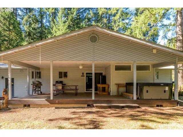 a view of house with wooden deck and furniture