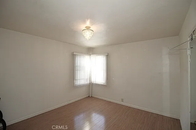 an empty room with windows and chandelier fan