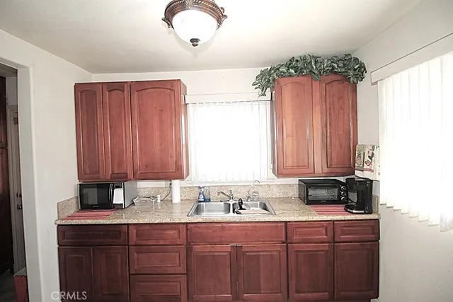 a kitchen with stainless steel appliances granite countertop a sink a stove a refrigerator and cabinets