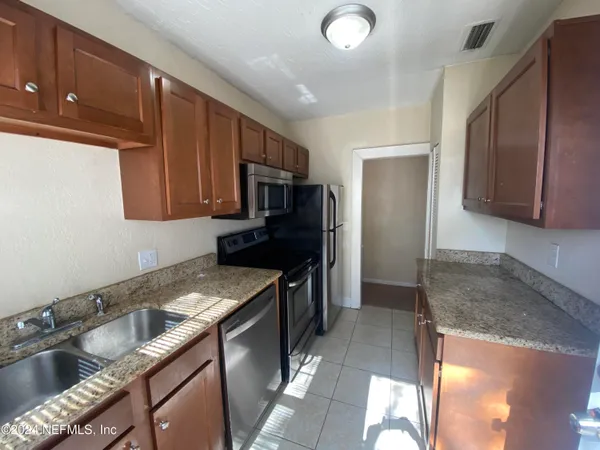 a kitchen with a sink stove top oven and refrigerator