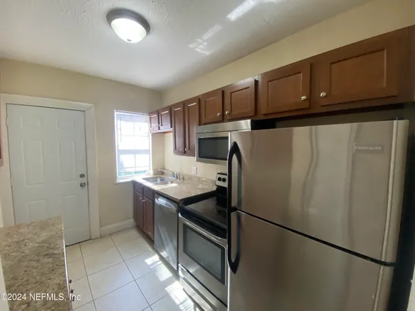 a kitchen with stainless steel appliances granite countertop a refrigerator a stove a sink and a cabinets