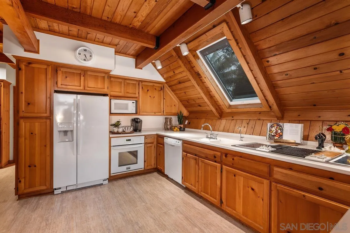 1366 Neptune Avenue Encinitas, CA 92024 - Photo 15 of 48 a kitchen with a sink cabinets stainless steel appliances and a window