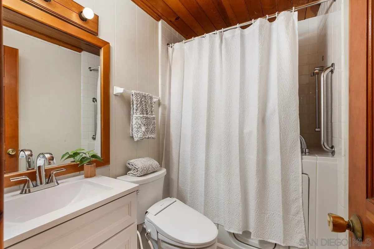1366 Neptune Avenue Encinitas, CA 92024 - Photo 19 of 48 a bathroom with a sink a toilet and shower curtain