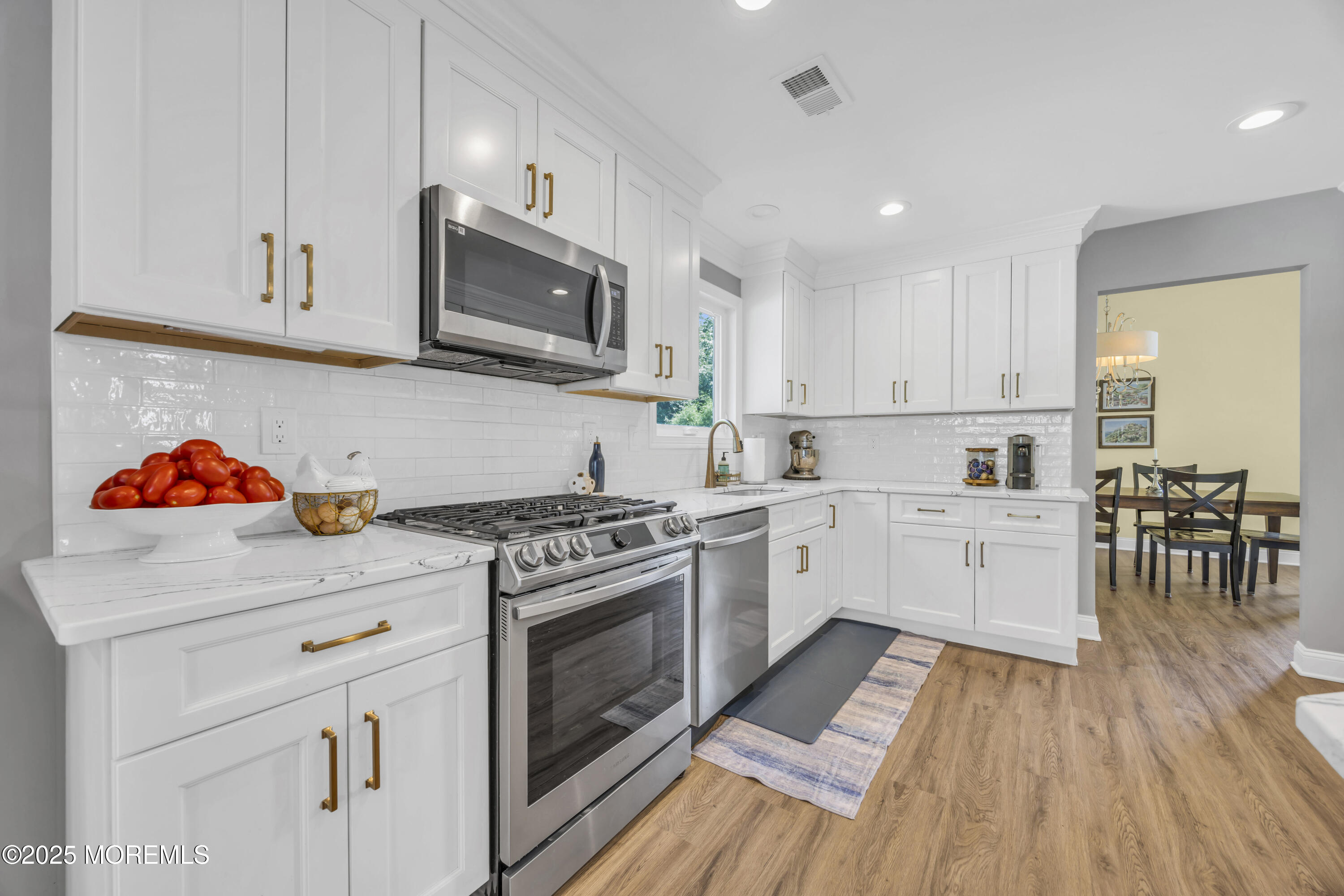 50 Diamond Lane Howell, NJ 07731 - Photo 19 of 49 a kitchen with white cabinets stainless steel appliances and wooden floor