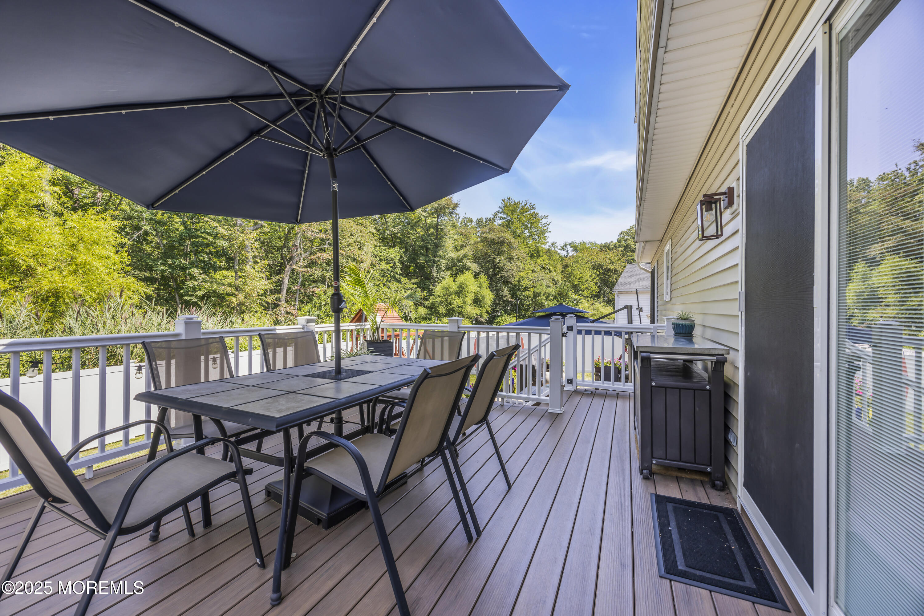 50 Diamond Lane Howell, NJ 07731 - Photo 39 of 49 a patio with wooden floor a yard a table and chairs
