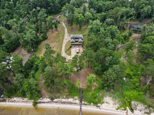 an aerial view of a house with a yard and lake view