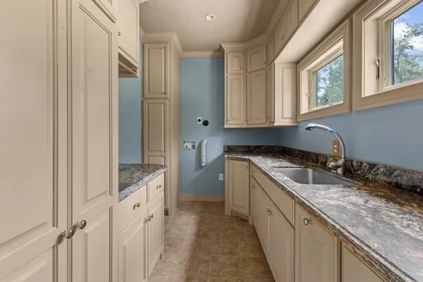 a kitchen with granite countertop a sink stove and cabinets