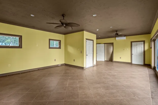 a view of a room with a ceiling fan and window